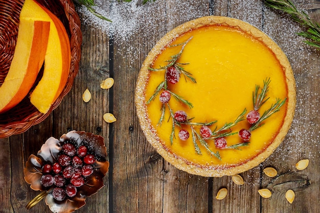 Pastel de calabaza festivo decorado con arándanos sobre fondo rústico, vista superior.