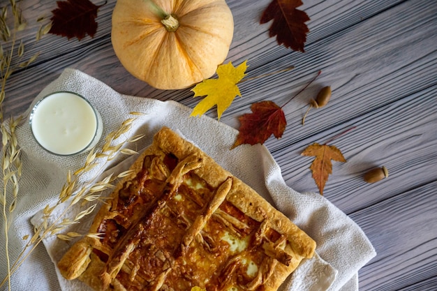 Foto pastel de calabaza laico plano con leche en vidrio sobre fondo blanco de madera