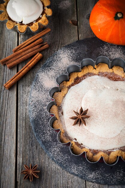 Pastel de calabaza con merengue y canela sobre superficie de madera vieja. Enfoque selectivo.