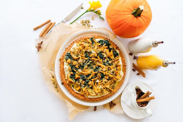 Pastel de calabaza con rebozuelos Una calabaza tallada en el fondo Plato tradicional de Halloween servido en una mesa con un mantel blanco Vista superior