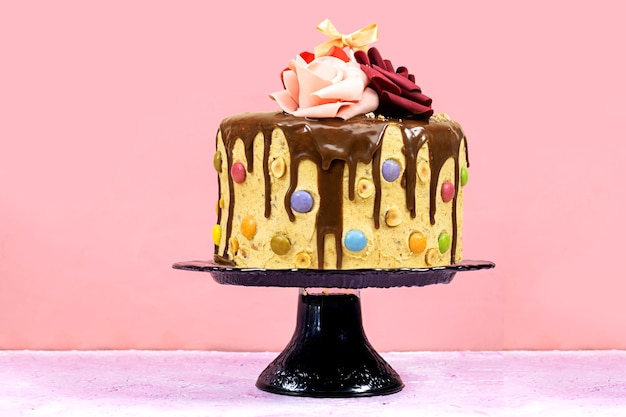 Pastel de capa de cumpleaños decorado con pedazos de chocolate con texto de feliz cumpleaños en tablero de madera.