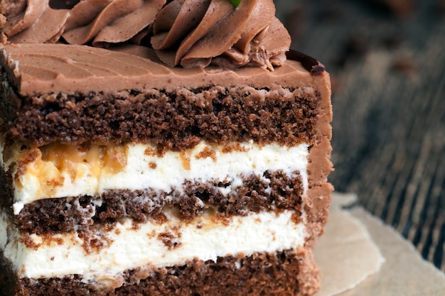 pastel en capas con pasteles de chocolate, crema de caramelo y avellanas, un trozo de pastel en capas con nueces y caramelo