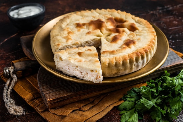 Pastel de carne Kubdari Pan plano georgiano sabroso Relleno de carne Fondo oscuro Vista superior