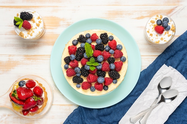 Pastel casero con bayas frescas sobre superficie de madera.