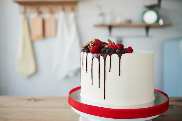 Pastel casero con cereza y chocolate en el interior de la cocina.