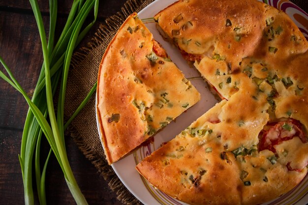 Pastel casero con pollo, hierbas y tomates en un plato.