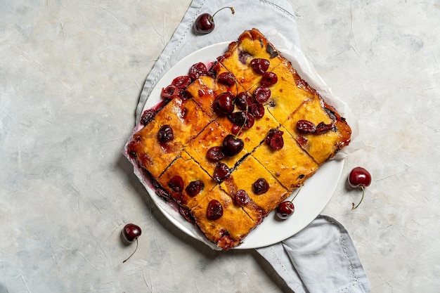 Pastel de cereza dulce recién horneado o pastel de brownie rojo en un plato con lavanda y bayas crudas a un lado