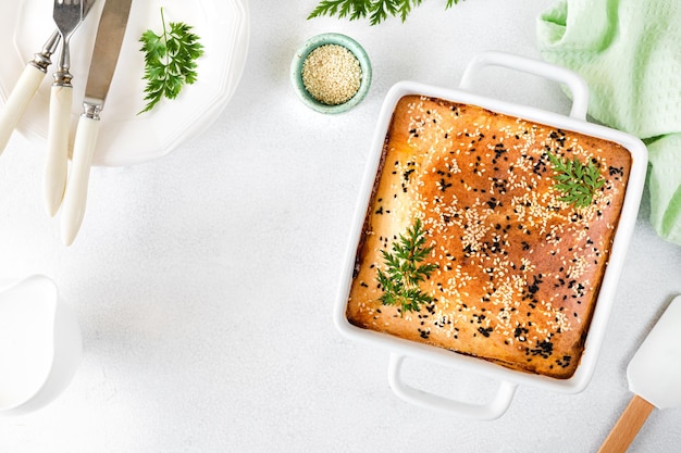 Pastel cerrado casero con verduras sobre un fondo de hormigón blanco