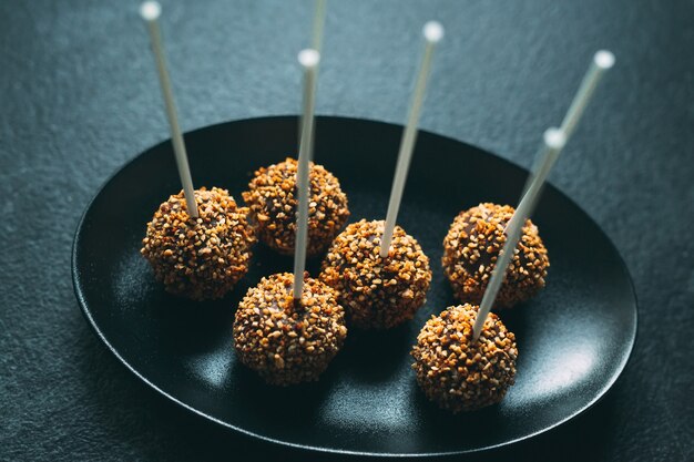 Pastel de chocolate aparece en un plato sobre un fondo oscuro.