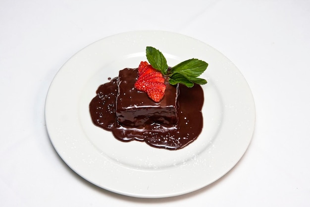 Pastel de chocolate con azúcar glas de fresa y comida de postre de bayas rojas de chocolate derretido