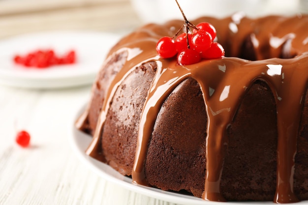 Pastel de chocolate con bayas de árbol de bolas de nieve en un plato sobre una mesa