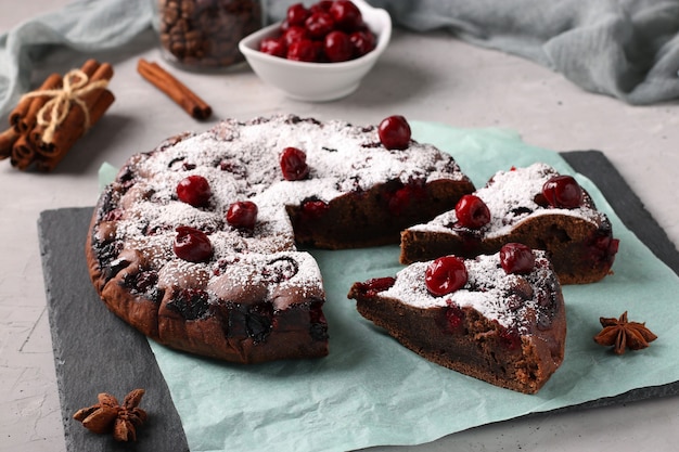 Pastel de chocolate casero con cerezas sobre un fondo gris. De cerca. Formato horizontal