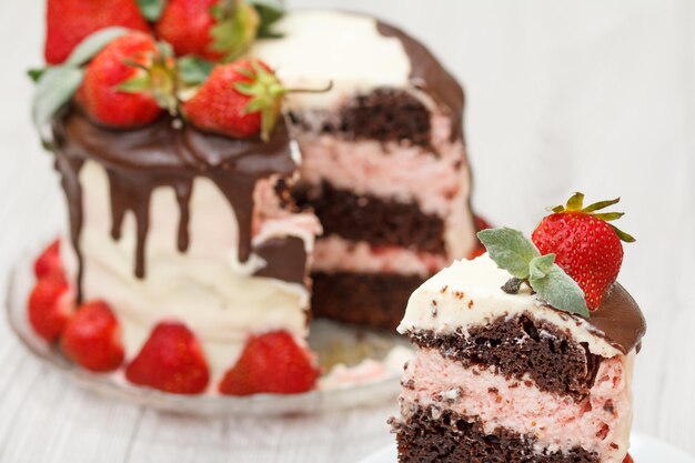 Pastel de chocolate casero decorado con fresas frescas y hojas de menta en una placa de vidrio