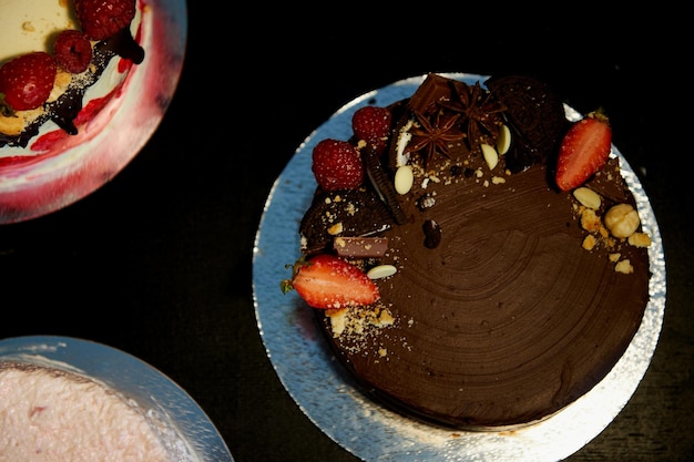 El pastel de chocolate con cerezas decorado con galletas de fresas y tarta de fresas Una obra maestra del arte culinario