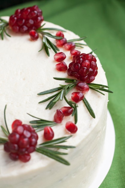 Pastel de chocolate con crema de bayas, crema de queso blanco, bayas de granada y ramas de romero. Idea para un pastel de cumpleaños o para un pastel de bodas.