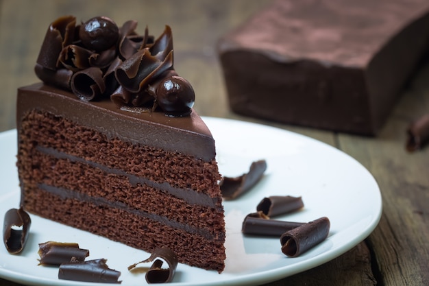 Pastel de chocolate con curl de chocolate sobre fondo de madera