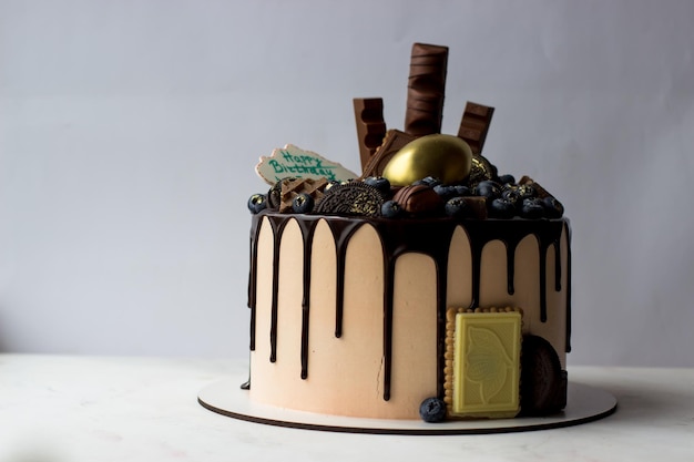 Pastel de chocolate decorado con galletas de arándanos y chocolates sobre un fondo blanco