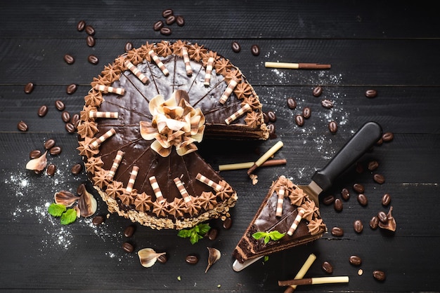 Pastel de chocolate dulce con crema sabrosa en el fondo de madera negra