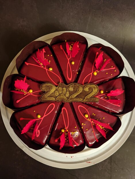 pastel de chocolate con hermosas decoraciones rojas de cerca. Números comestibles 2022. Año nuevo.