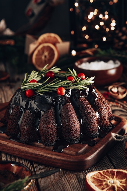 Pastel de chocolate navideño decorado con frutos del bosque y romero