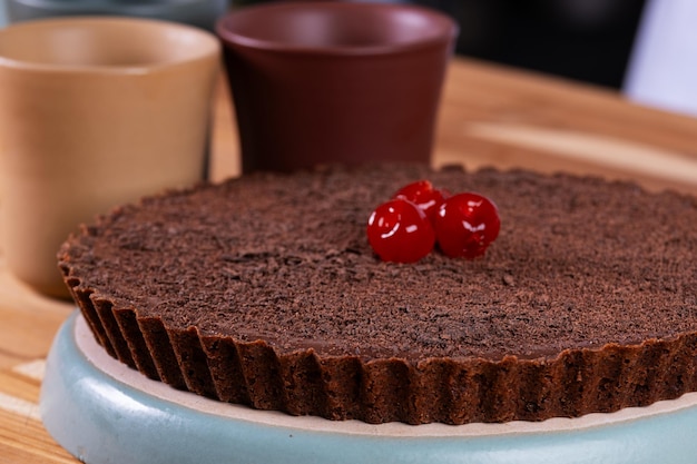 pastel de chocolate oscuro decorado con cerezas