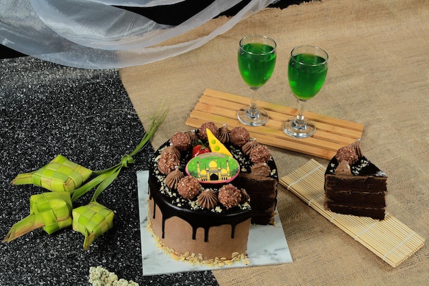 Un pastel de chocolate con un pastel de chocolate y dos vasos de té verde.