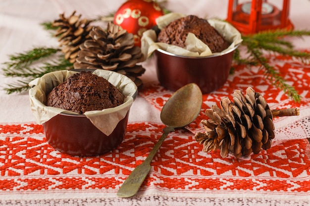 Foto pastel de chocolate y pastelitos con decoraciones en mesa rústica