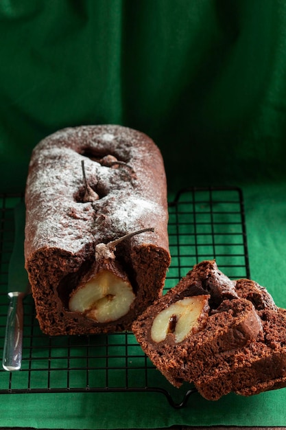 Pastel de chocolate y pera sobre un fondo verde. Estilo rústico, enfoque selectivo.