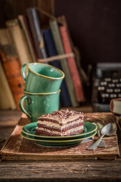 Pastel de chocolate y tazas de café en el escritorio del escritor