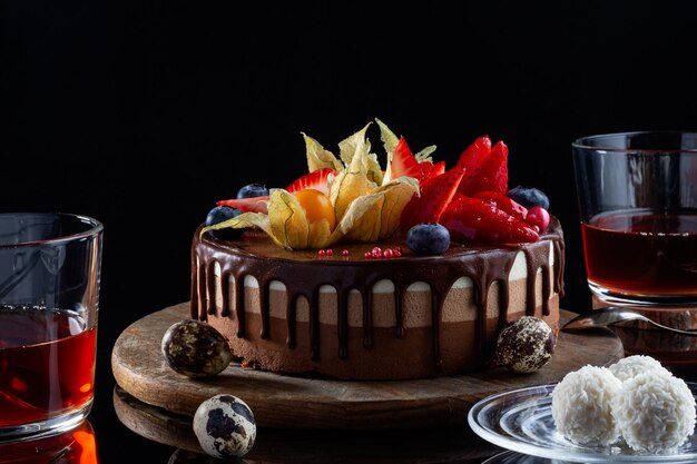 Pastel de chocolate tres pasteles de vista lateral de chocolate y té con dulces copos de coco y huevos de codorniz de chocolate Pastel apetitoso de vista lateral de bajo perfil para el almuerzo de Pascua