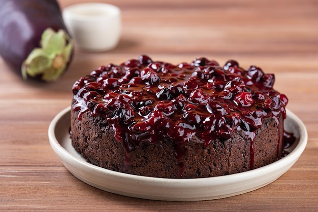 Pastel de chocolate vegano con mermelada de bayas en una mesa de madera. Sin azúcar, gluten ni lactosa.