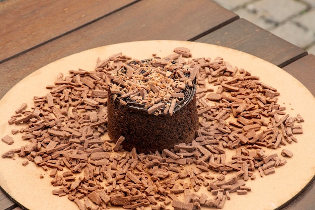 Pastel de chocolate con virutas de chocolate y crema de chocolate en una mesa de bistró rústica fuera de primer plano