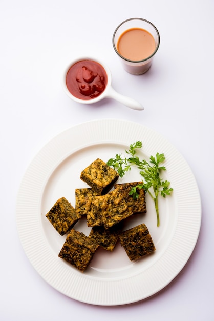 El pastel de cilantro o Kothimbir Vadi es una popular cocina maharashtriana hecha con hojas de cilantro. servido con salsa de tomate. enfoque selectivo