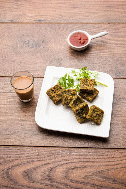 El pastel de cilantro o Kothimbir Vadi es una popular cocina maharashtriana hecha con hojas de cilantro. servido con salsa de tomate. enfoque selectivo