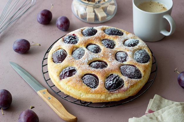 Pastel de ciruela sobre un fondo rosa. Horneando. Comida vegetariana.