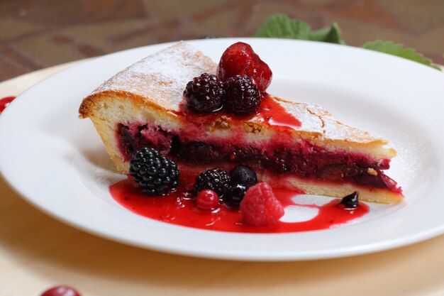 Pastel con ciruelas pasas y frutos del bosque.