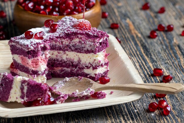 Foto un pastel de color granate con el sabor de diferentes bayas y un relleno de leche cremosa de requesón con semillas de granada