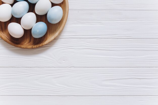 Pastel colorido azul, branco e cinzento ovos de Páscoa em placa de madeira
