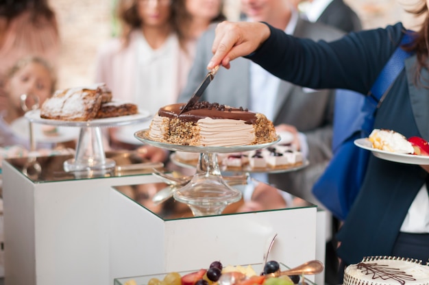 Pastel de corte de mujer en un catering