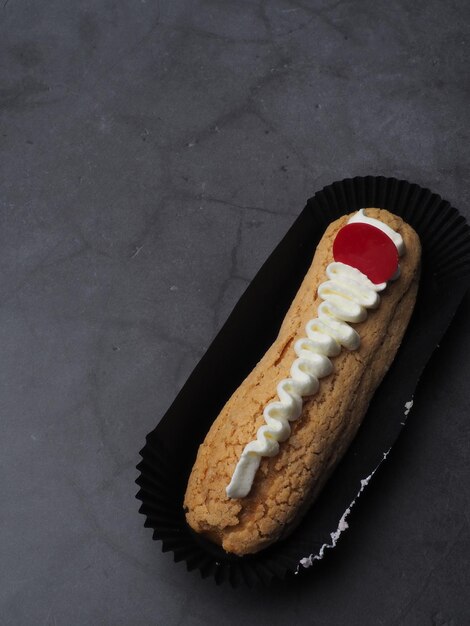 Un pastel con crema y una cereza encima.