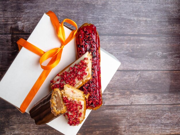 Pastel con crema y chocolate ECLAIRS sobre mesa de madera