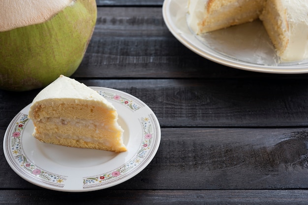 Pastel de crema de coco con fruta de coco sobre fondo de madera