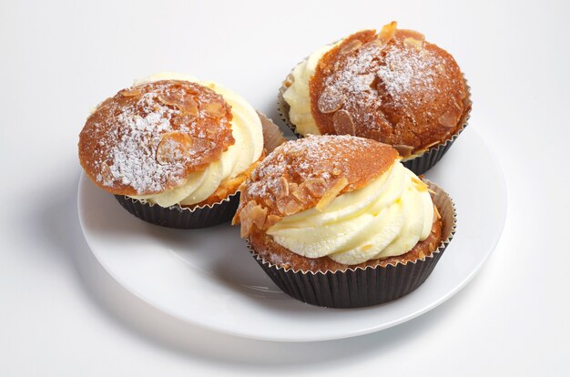 Pastel con crema de mantequilla y almendras sobre fondo blanco.