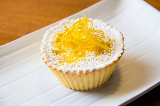 Pastel de crema pastelera con azúcar en polvo y frutas confitadas