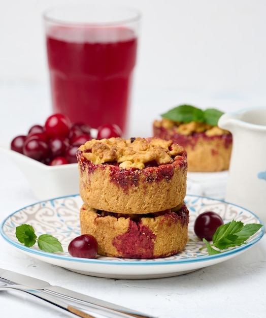 Pastel de crumble de cereza en porciones sobre un fondo blanco de la placa