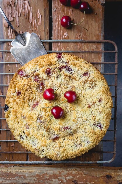 Pastel de crumble de cerezas caseras con bayas frescas en rústico