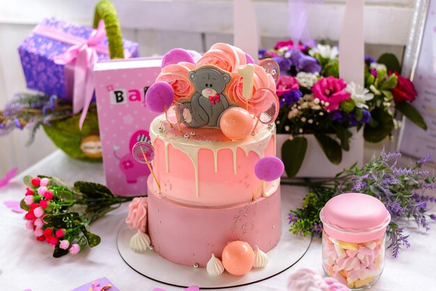 Pastel de cumpleaños de un año en rosa con oso gris.