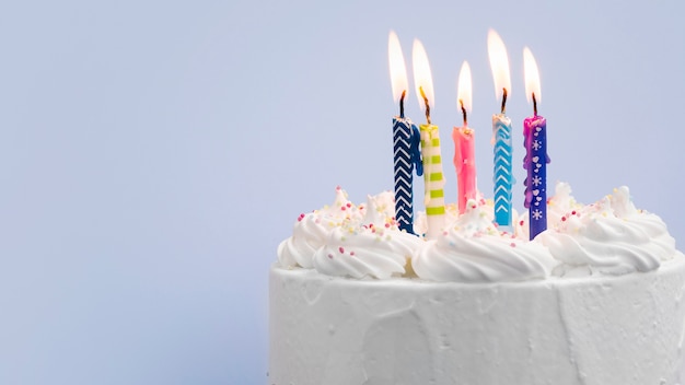 Foto pastel de cumpleaños con velas sobre fondo azul.