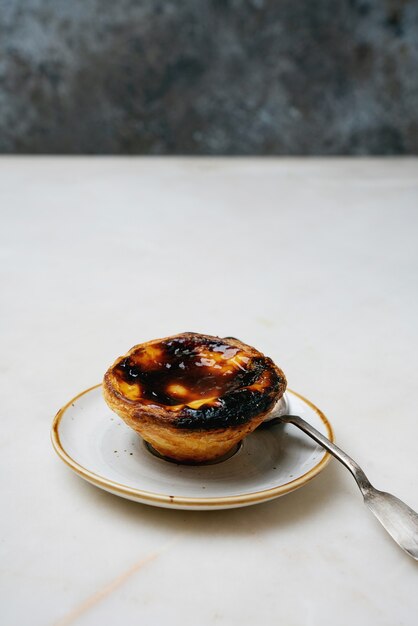 Pastel de nata. Sobremesa tradicional portuguesa, torta de ovo sobre fundo de mármore na frente de fundo rústico de metal. Foco seletivo