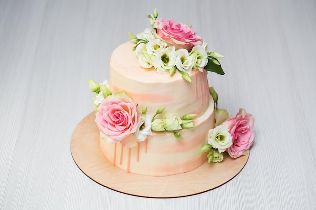 Pastel escalonado con flores frescas y macarrones